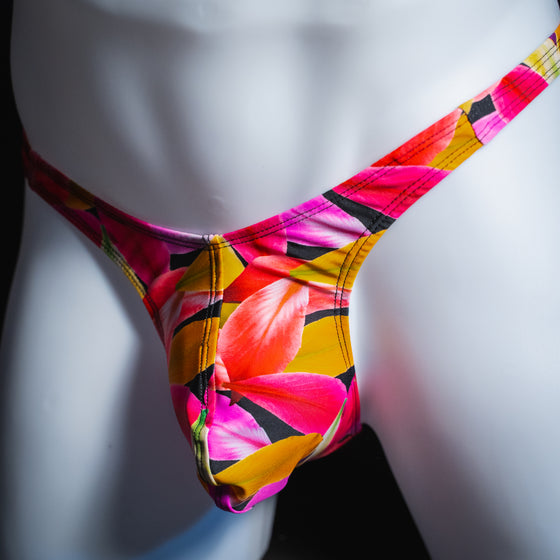 Men's bright floral thong, slim cut, angled front view.