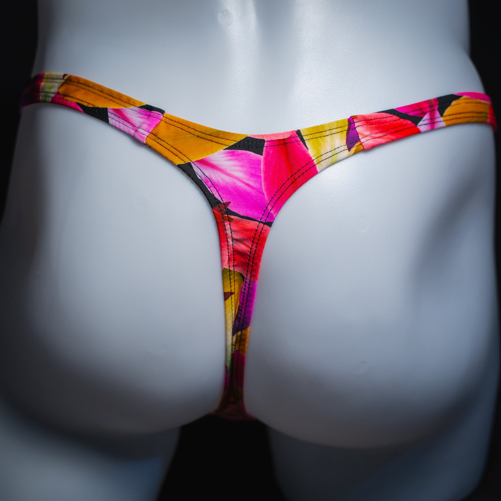 Men's bright floral thong, slim cut, rear view.