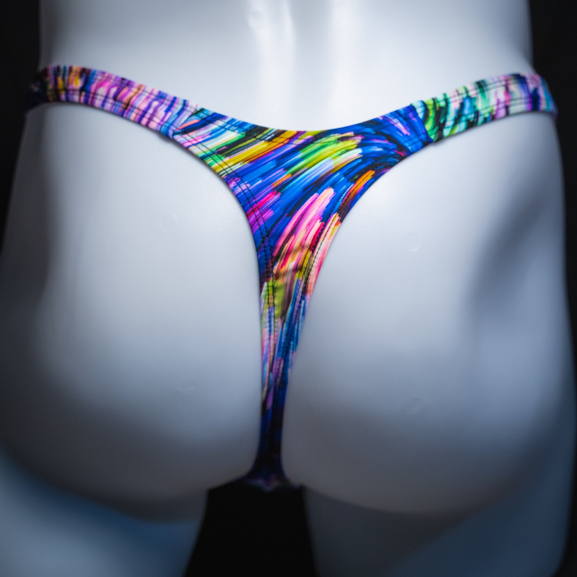 Men's colorful light trails thong, slim cut, rear view.