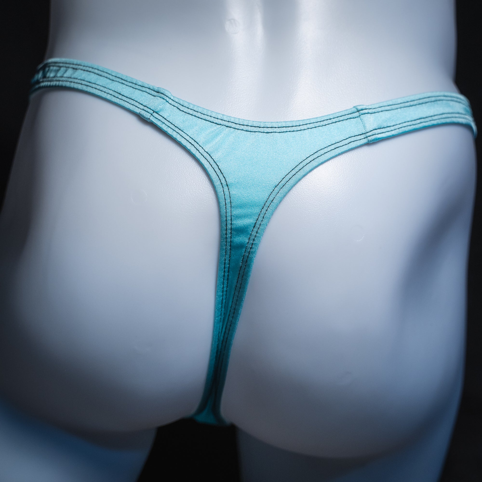 Men's solid light blue thong, slim cut, rear view.