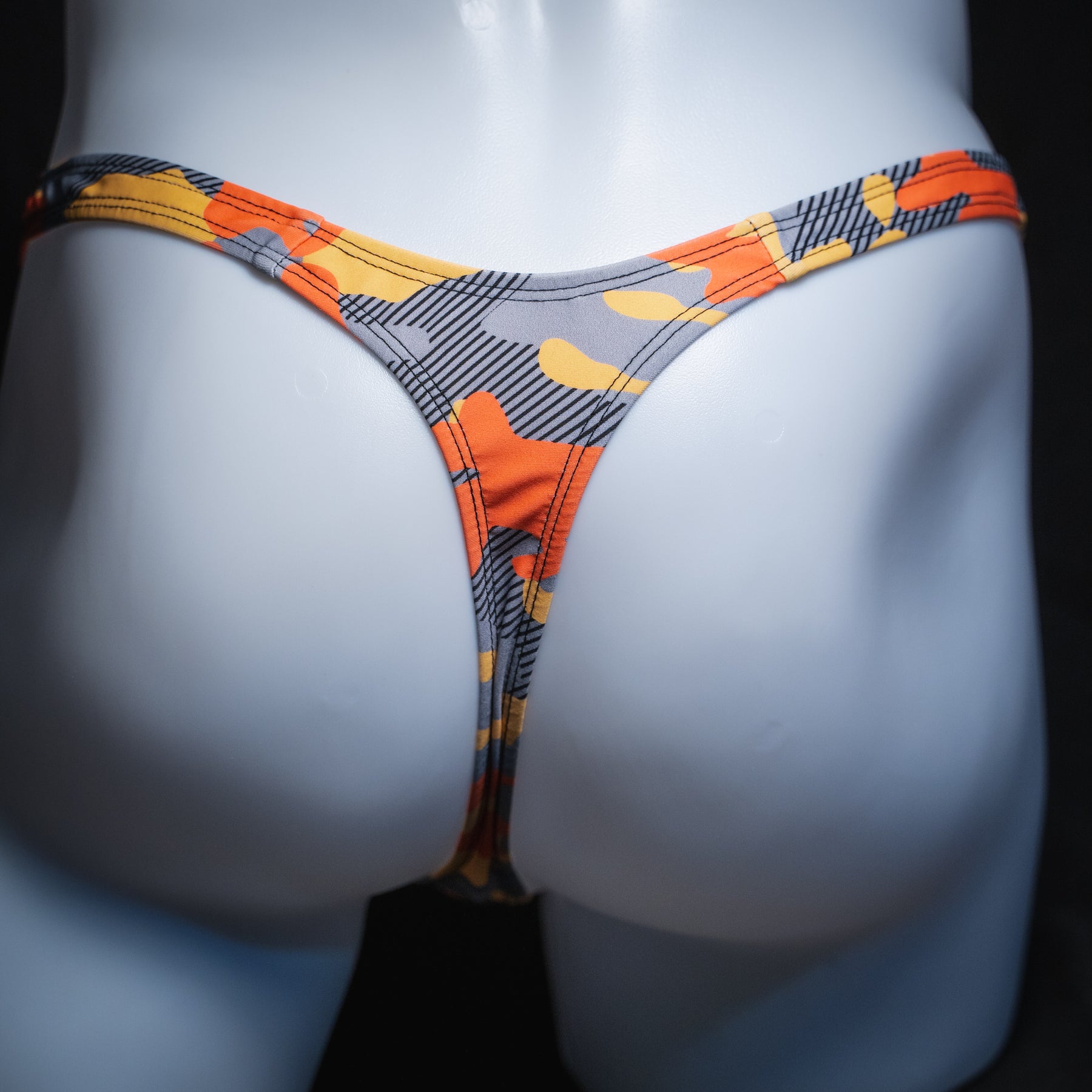 Men's orange and gray camo thong, slim cut, rear view.