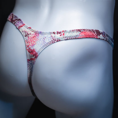 Men's pink snakeskin thong, slim cut, angled rear view.