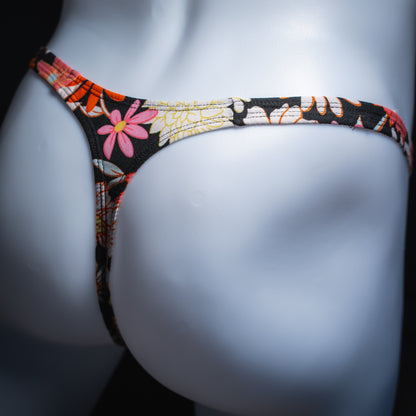 Men's floral thong, slim cut, angled rear view.