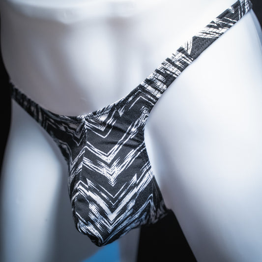 Mens' black and white zig zag striped thong, slim cut, angled front view.