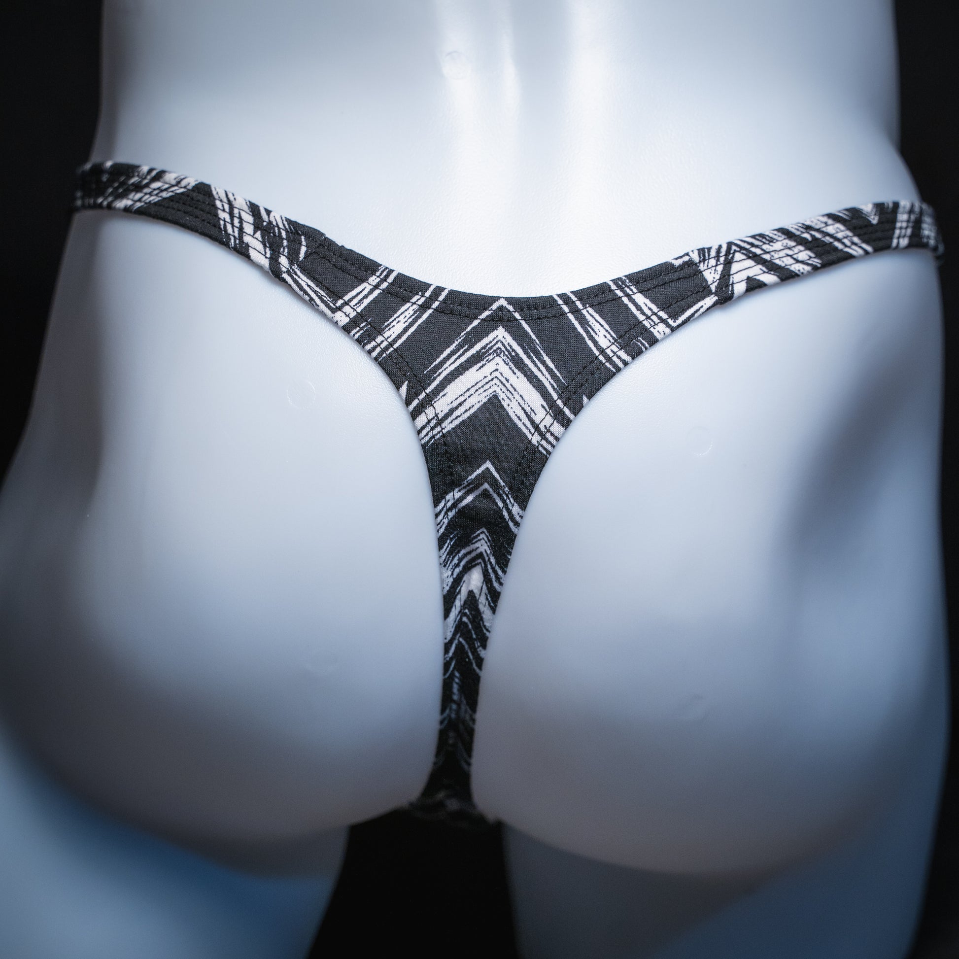 Mens' black and white zig zag striped thong, slim cut, rear view.