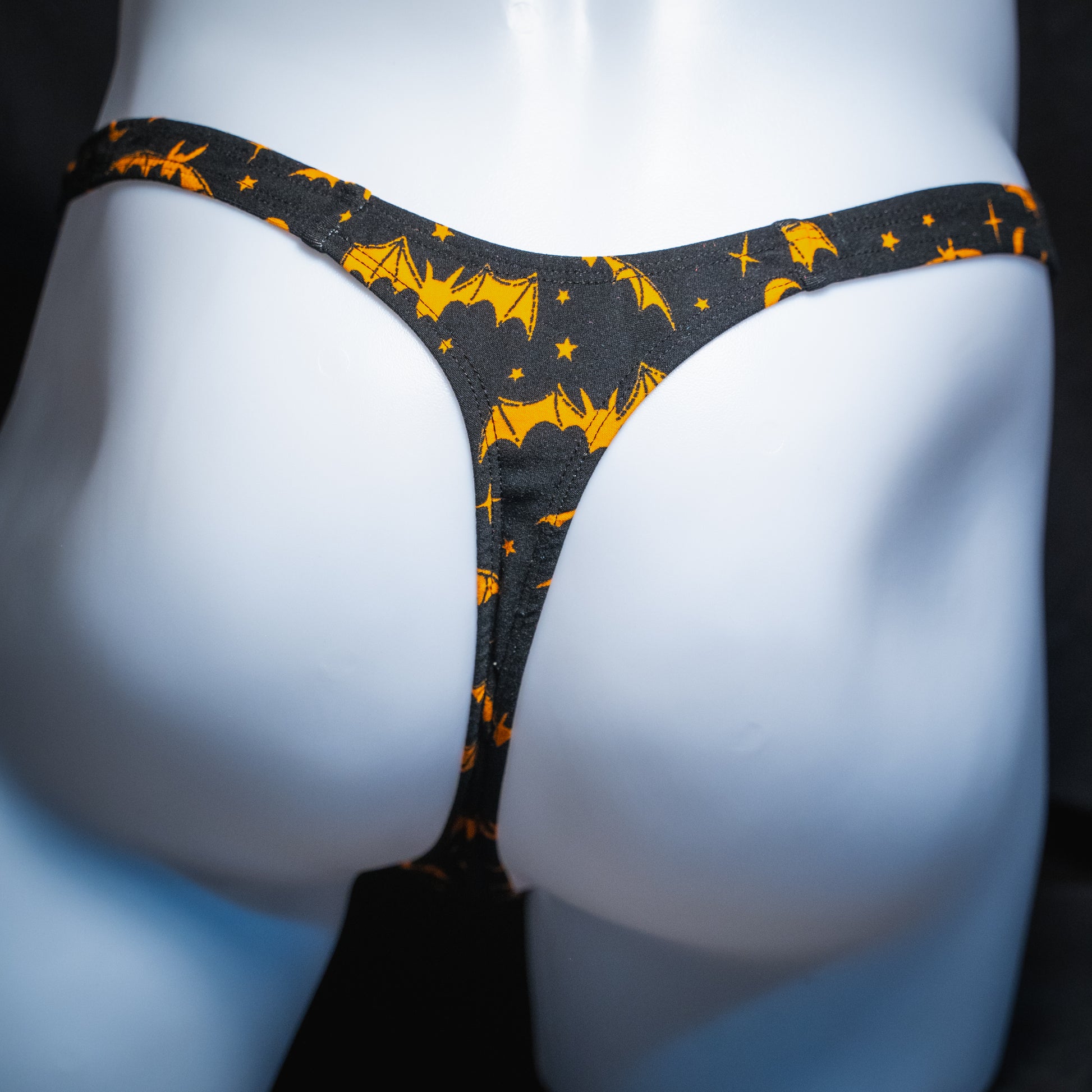 Men's thong underwear, halloween black and orange bats and moons print, polyester, handmade, slim cut, back view