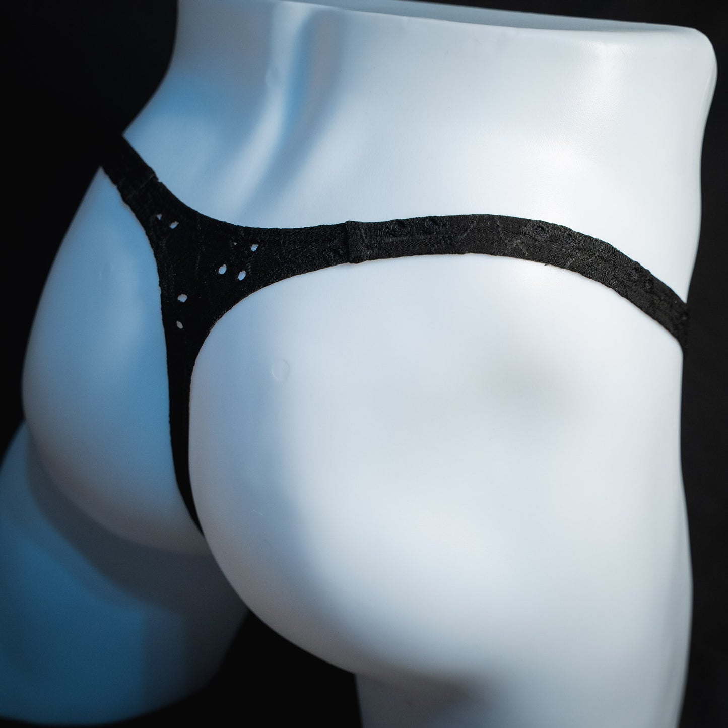 handmade mens thong underwear, solid black eyelets, soft polyester material, classic cut variation, angled back view