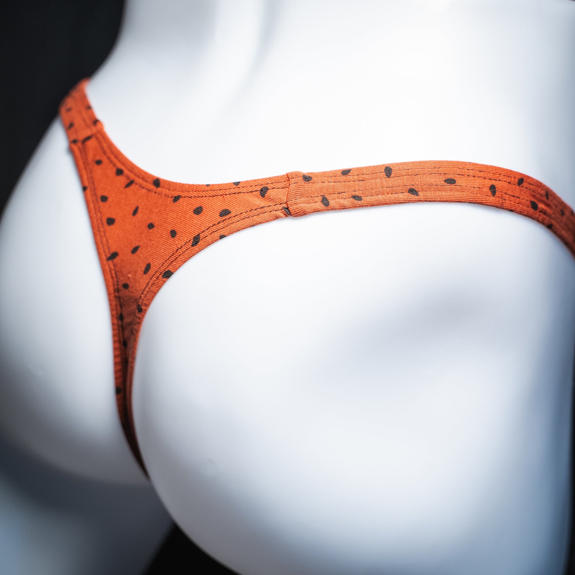 Men's red watermelon seeds thong, slim cut, rear view.
