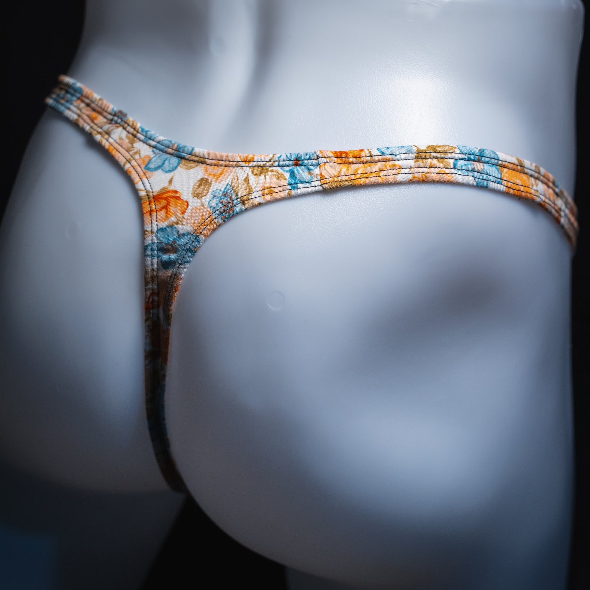 men's floral thong shown in classic cut from an angled back view