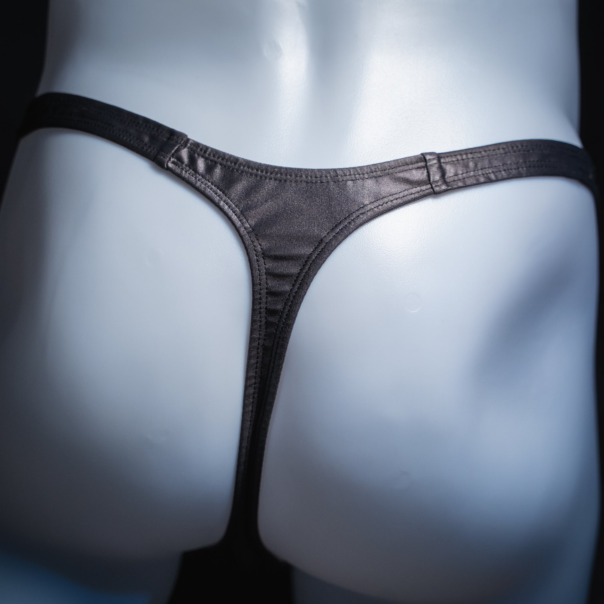 Men's gray wet look thong, classic cut, back view.